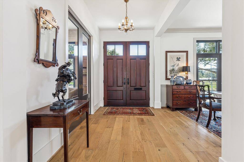 Gracious entry hall with wide plank French oak engineered hardwoods open to the library and dining room.