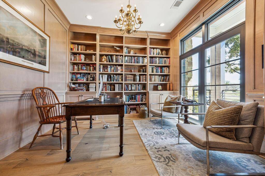 Library with wall of bookshelves overlooks the front porch and yard. Beautiful blonde wood paneling compliment the light French oak engineered floors.  Office from home with custom built in printer station and enjoy the work day in this tranquil setting.