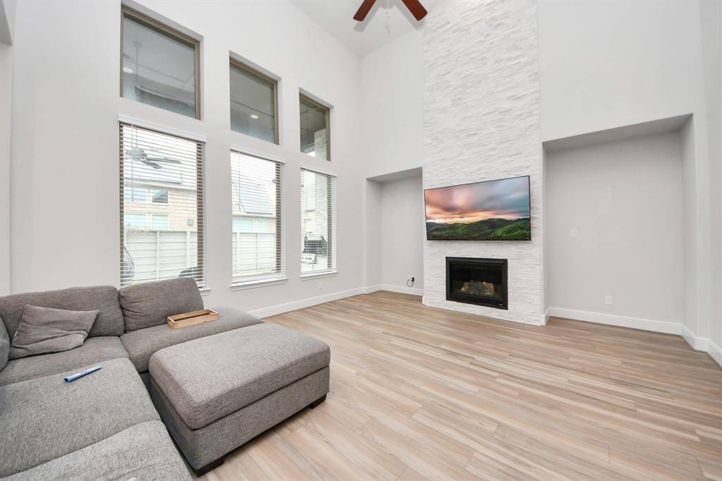 Stacked stone fireplace takes the focal point of the room with niches on both sides and a great view of the covered patio and backyard.