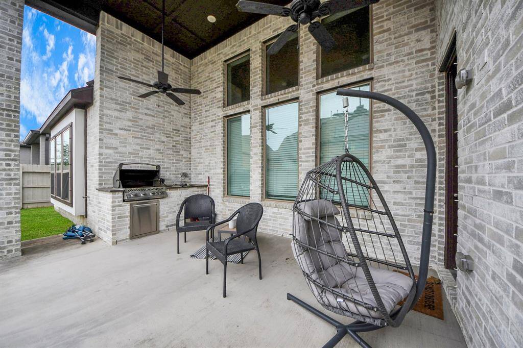 The charming covered back porch is perfect for outdoor living, featuring an outdoor kitchen, ceiling fans for added comfort, and plenty of room for furniture to relax and entertain. The backyard offers a cozy and inviting space to enjoy the outdoors, whether you're hosting guests or unwinding after a long day.