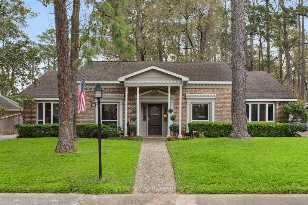 Timeless Curb Appeal & Classic Charm. Welcome to 607 Briarpark Drive, a stunning traditional-style home nestled among mature trees in a picturesque setting. The front elevation boasts elegant brickwork, detailed architectural trim, and a charming columned entryway, all set against a backdrop of lush greenery.