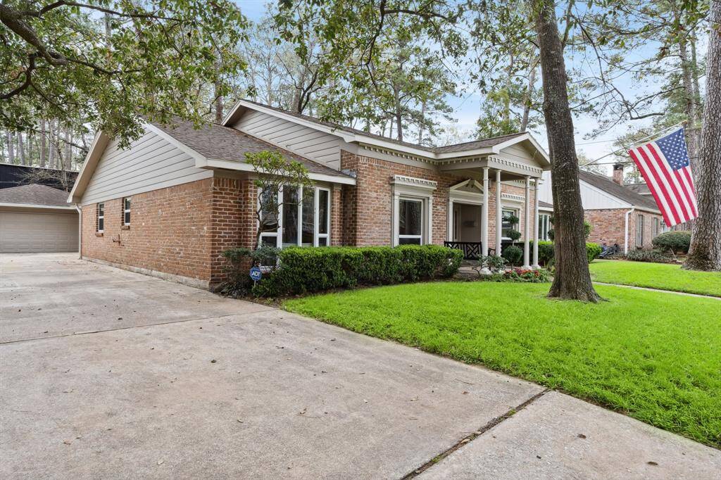 Expansive driveway and detached two-car garage ensure ample parking and enhanced privacy. Surrounded by mature trees and lush landscaping, the home creates a serene and private setting in Briargrove Park.