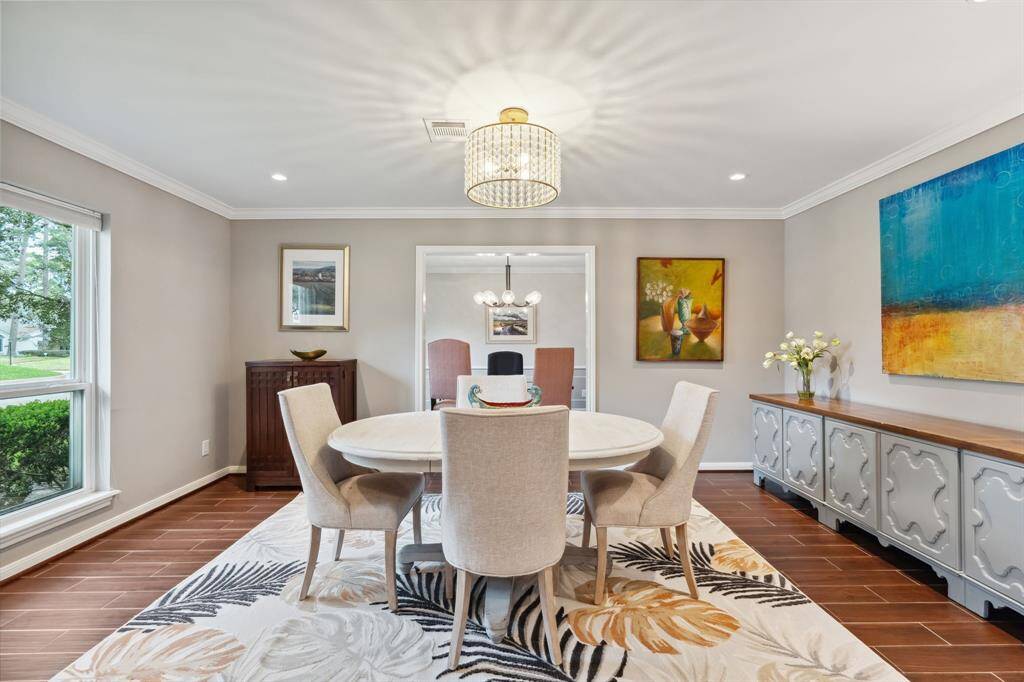Abundant sunlight fills this spacious and refined dining area, creating a warm and inviting ambiance. Graceful architectural details and an eye-catching chandelier make this the perfect space for hosting memorable dinners and special occasions.