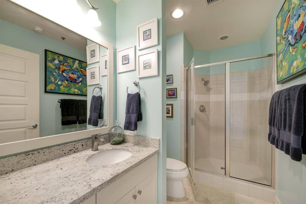 Secondary bath includes stone counter tops and a shower.