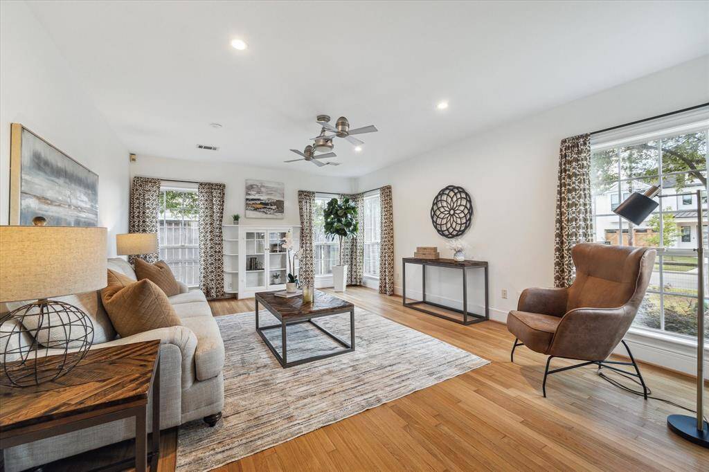 The main living room is filled with light from its many windows, has original hardwoods and a charming vintage built-in cabinet.