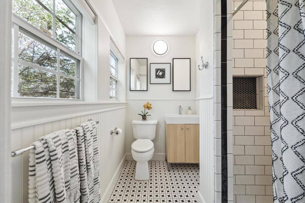 En-suite bath off of the primary bedroom featuring vintage inspired tilework and an oversized shower.