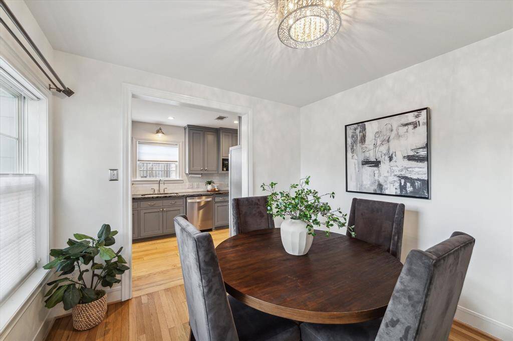 The lovely dining room has a wall of windows and sparkling chandelier light fixture.