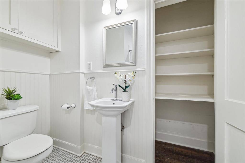 The main bath has a graceful pedestal sink and a large linen closet for extra storage.