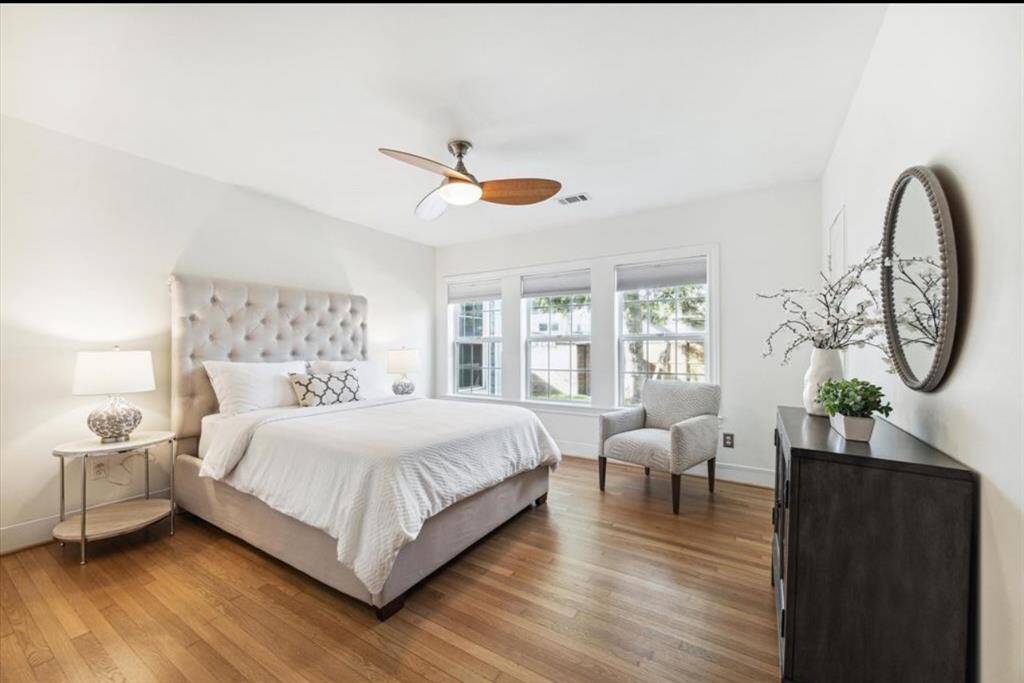 The spacious Primary bedroom features blackout shades, hardwood floors and an ensuite bath.