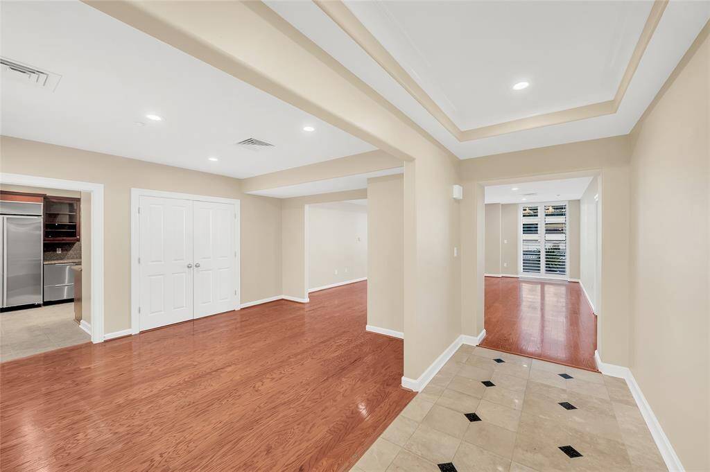 The inviting view as you enter the home. Marble floors and tray inset ceiling of Entry Hallway give a sense of separation from the Dining Room on left and large Living Room in background. Double doors on left are HVAC closet.