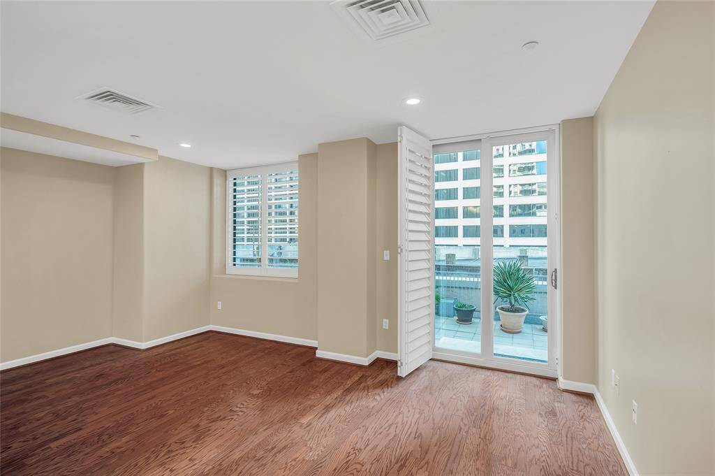 The sliding doors to terrace with plantation shutters open.  All windows in home overlook the terrace with skyline in background.
