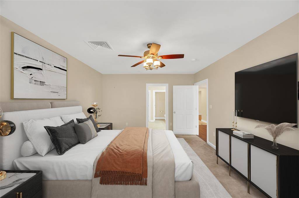 Another view of Primary Bedroom. Ceiling fan above with wall mounted controls. PHOTO VIRTUALLY STAGED.