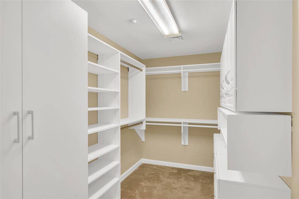 The Walk-In Closet is approx. 12'x7'* with custom organization system by California Closets. This boutique-like closet offers hanging rods, open shelving, cabinet storage and drawer storage. *Buyer to verify dimensions.