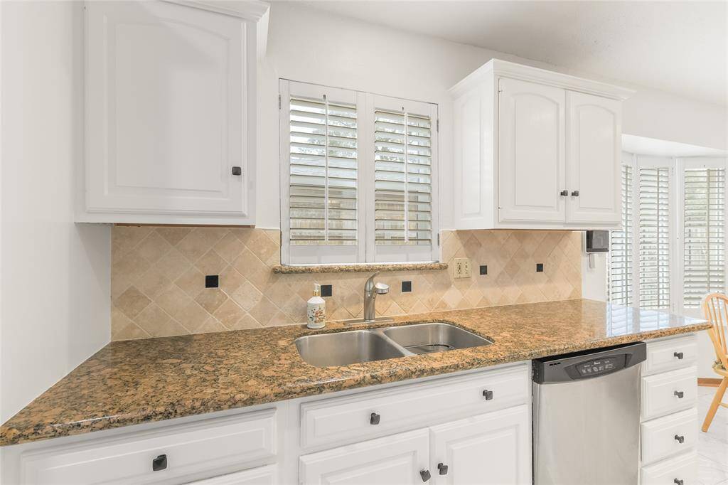 Equipped with stainless steel appliances, a deep double sink, and recessed lighting, this kitchen is as functional as it is stylish.