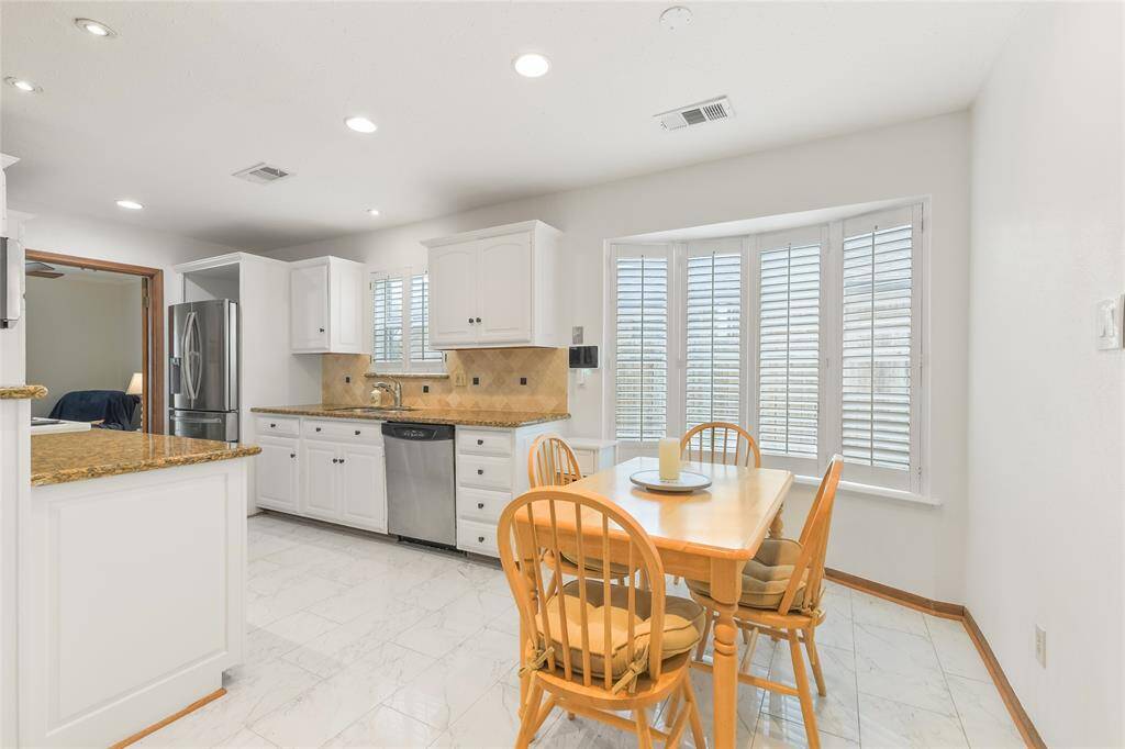 Start your mornings in this charming breakfast nook, bathed in natural light from the beautiful bay window with plantation shutters—offering privacy while maintaining a bright and airy feel.