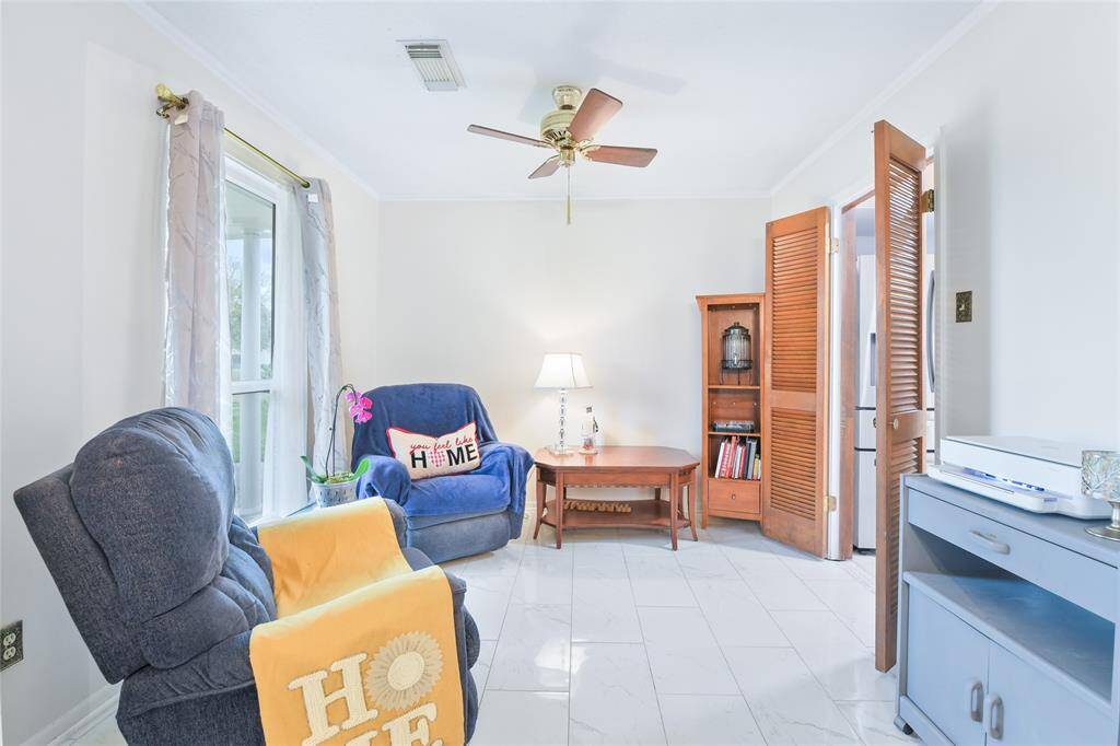 This bright and inviting sitting area, located just off the kitchen, offers the perfect space for relaxation, reading, or casual conversation. Large windows bring in plenty of natural light, creating an airy and welcoming atmosphere.