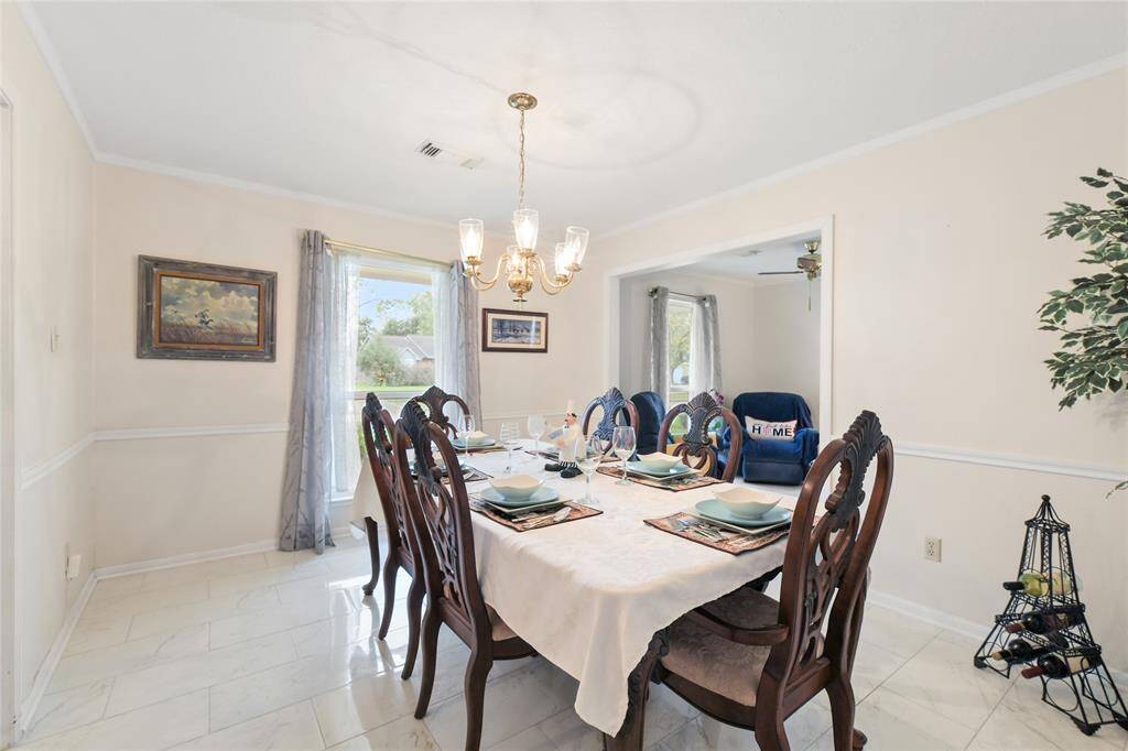 Step into this bright and inviting dining room, where timeless charm meets modern elegance.Large windows with stylish drapery flood the space with natural light, enhancing the airy feel of the room.