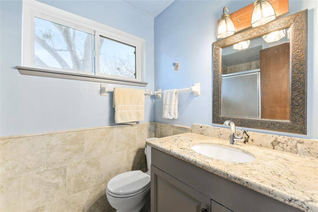 A private en-suite bathroom offers convenience and privacy, with a modern tiled shower and natural light from the window.