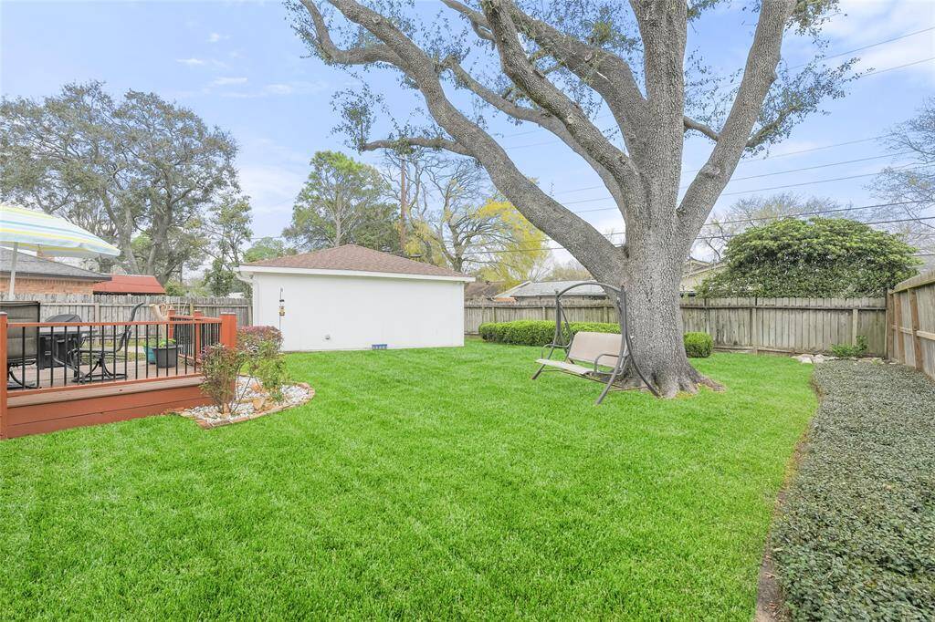 Surrounded by a lush, manicured lawn and mature trees, this private outdoor space provides a serene escape. The fenced yard ensures privacy, making it an ideal setting for pets, children, or quiet relaxation.