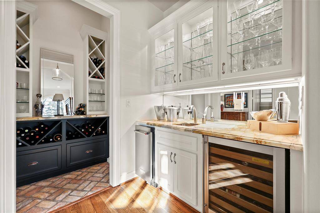 Originally designed as an elevator shaft, this refined wine grotto has been thoughtfully transformed into an elegant retreat for wine enthusiasts. Featuring antique brick flooring, custom granite countertops, and sleek glass shelving, the space seamlessly blends function with sophistication