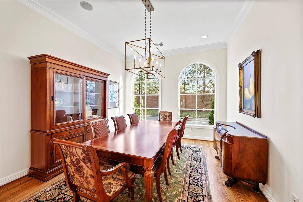 The formal dining room is a refined space featuring elegant architectural details, a statement chandelier enhances the ambiance, while built-in ceiling speakers add to the dining experience. This room is designed for memorable gatherings
