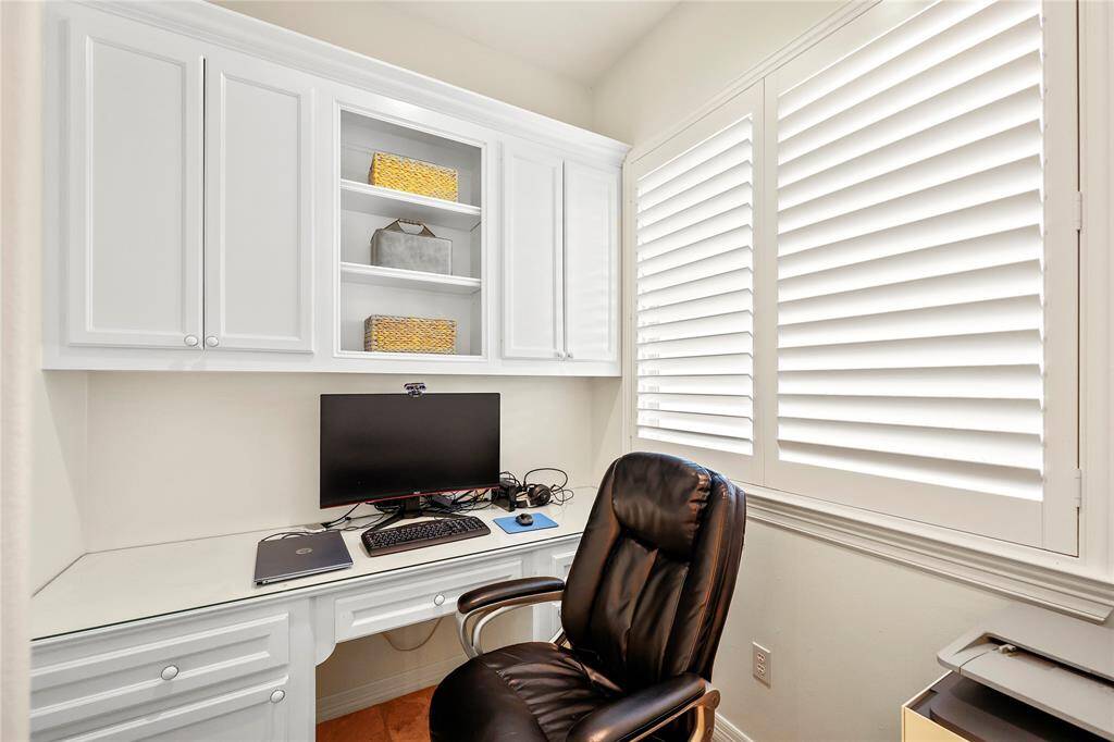 Located just off the primary bath, this private study/vanity area features a built-in desk and ample cabinet storage. An ideal space for working from home