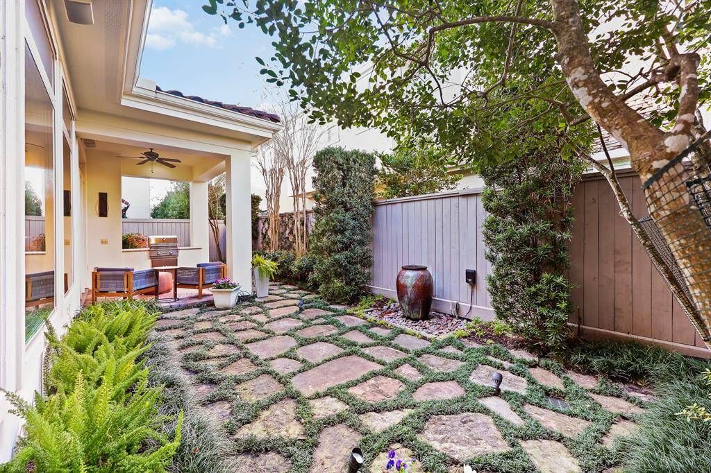 This private, fenced backyard retreat features a beautifully paved flagstone walkways tranquil fountain, and lush landscaping.