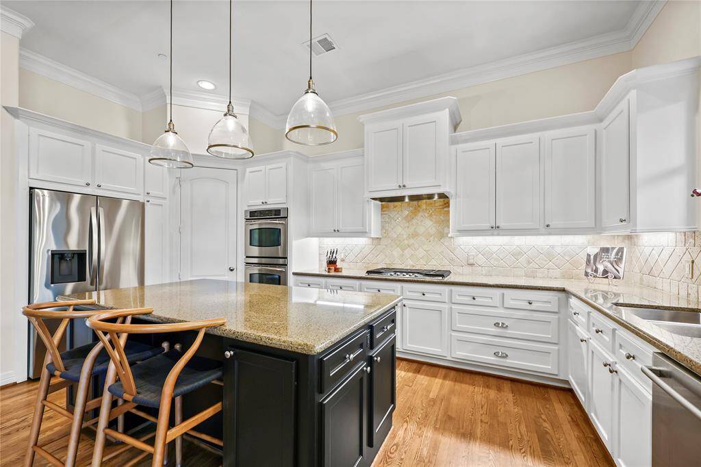 This gourmet kitchen blends elegance and functionality with its spacious island, providing ample workspace, additional storage, and breakfast bar seating