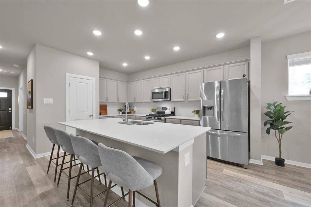 Plentiful cabinets, quartz countertops, and a sizeable island give you plenty of storage and space to prepare meals and enjoy the company of family and guests.