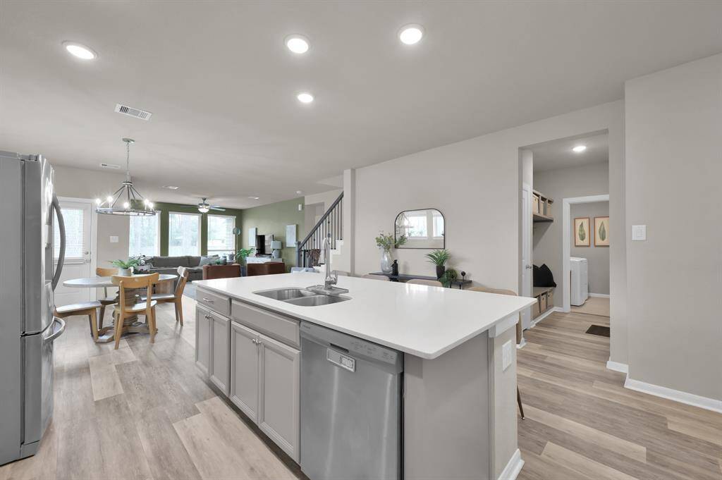 This angle gives a great view of how open the kitchen is to the dining and living room. Across the kitchen is a hallway to the laundry room, garage, and storage closet.