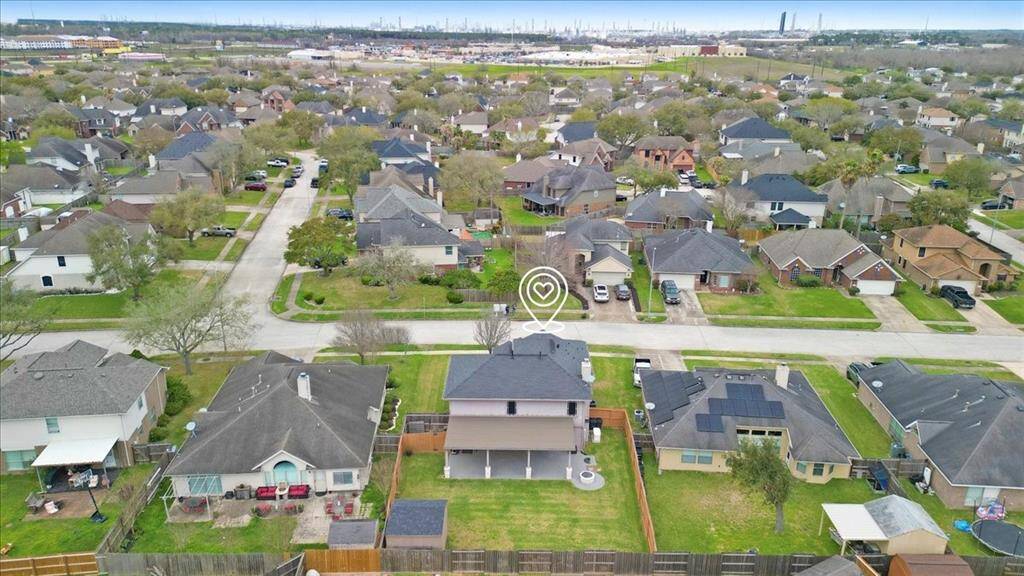This photo showcases a suburban neighborhood with well-maintained homes, featuring spacious backyards and manicured lawns.