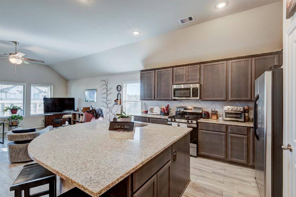 Kitchen offers plenty of storage space, natural lighting, and extended bar top.