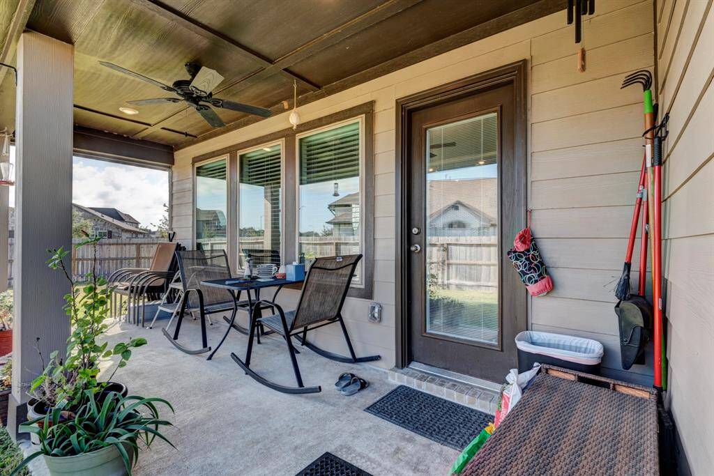 Extended covered back porch has a ceiling fan and plenty of light.