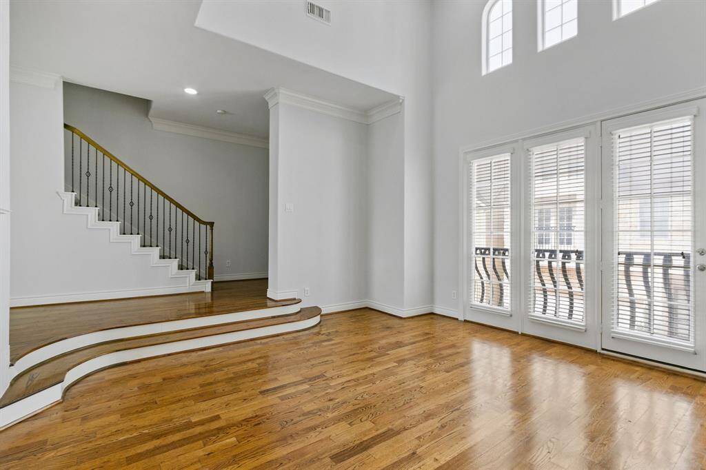 Spacious family room with fresh paint, soaring ceiling, hardwood floors and great views from wall of windows with door to balcony.