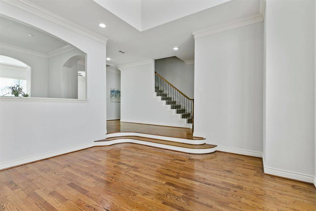 View from the spacious family room with soaring ceiling and wonderful architectural details to the staricase and dining area.