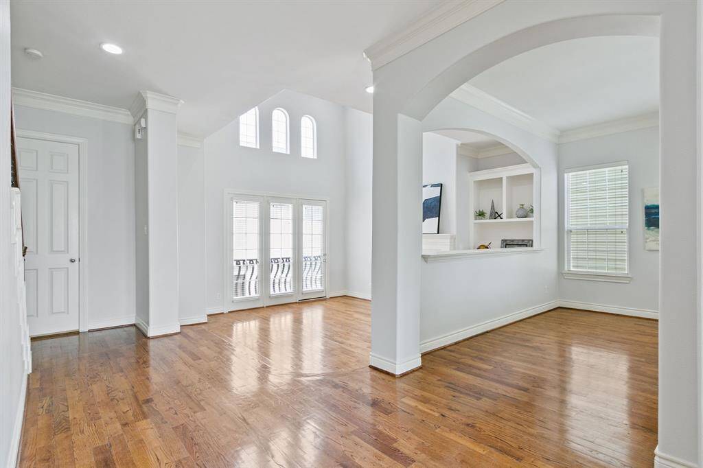 View looking to the spacious family room and dining area with hardwood floors and wonderful architectural details.