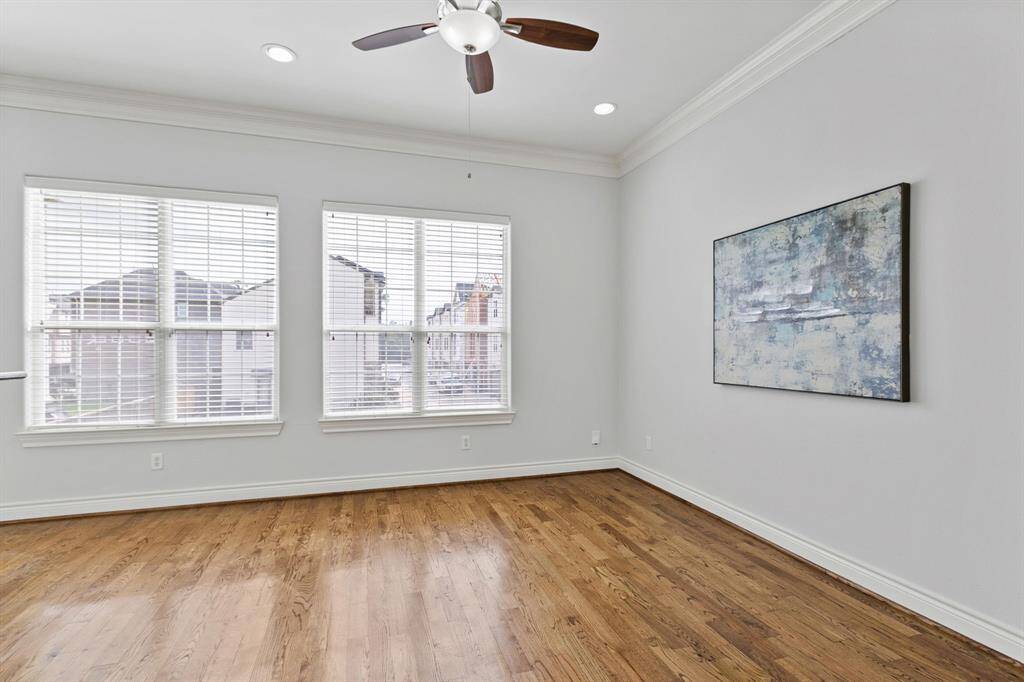 Another view of huge living or breakfast area with wonderful windows for natural light and wonderful hardwood floors and ceiling fan.