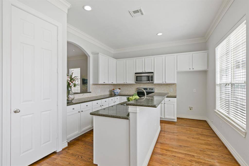 Gourmet island kitchen has stainless steel appliances, granite countertops, breakfast bar and lots of cabinets for storage.