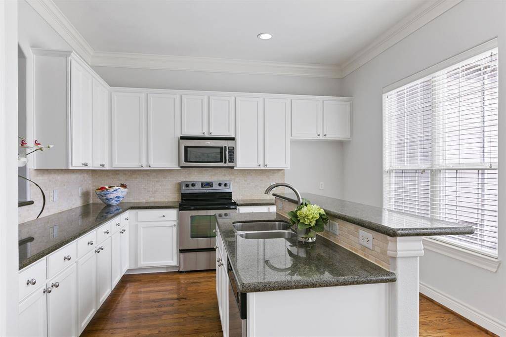 Gourmet island kitchen has double stainless steel sinks, stainless steel appliances, granite countertops, breakfast bar, great natural lighting and fresh paint.
