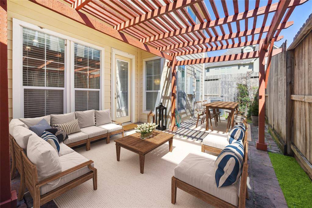 Relax in the private backyard oasis underneath the pergola. (virtually staged)