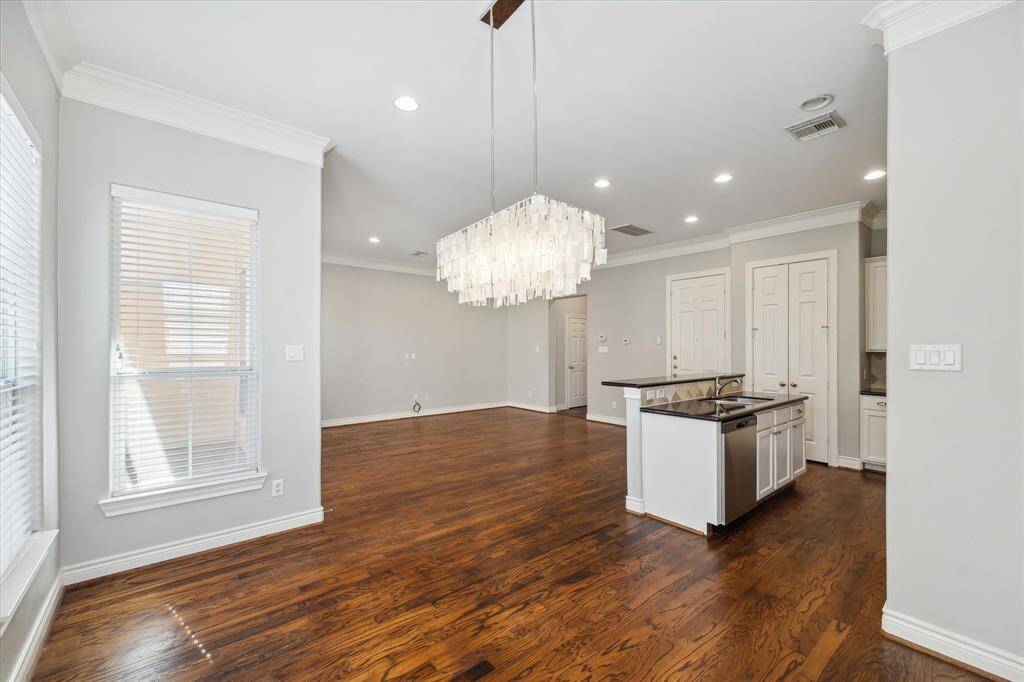 Elegant chandelier centerpiece in an open-concept dining area, seamlessly connected to the kitchen and living space.
