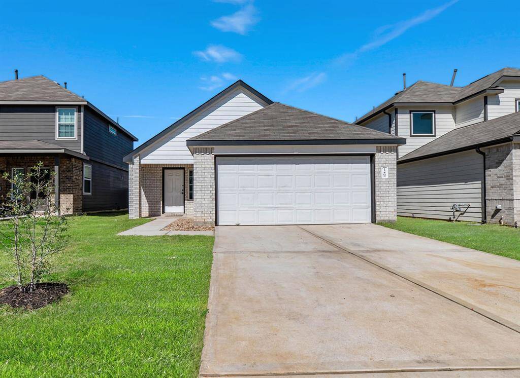 A modern single-story home with a two-car garage, a neatly maintained front lawn, and a concrete driveway. The exterior features a combination of light brick and siding, giving it a clean, contemporary look.