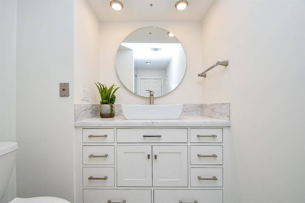 The recently remodeled primary bath features luxurious marble tile and a modern sink with sleek finishes.