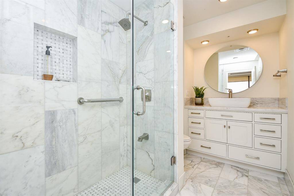 The oversized primary shower is a true standout, featuring elegant marble tile and a seamless marble surround, offering a spa-like experience in the comfort of your home.