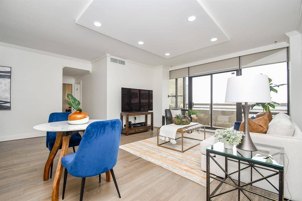 This open-plan living and dining area boasts recently replaced hardwood floors and recessed lighting, creating a modern and inviting space.