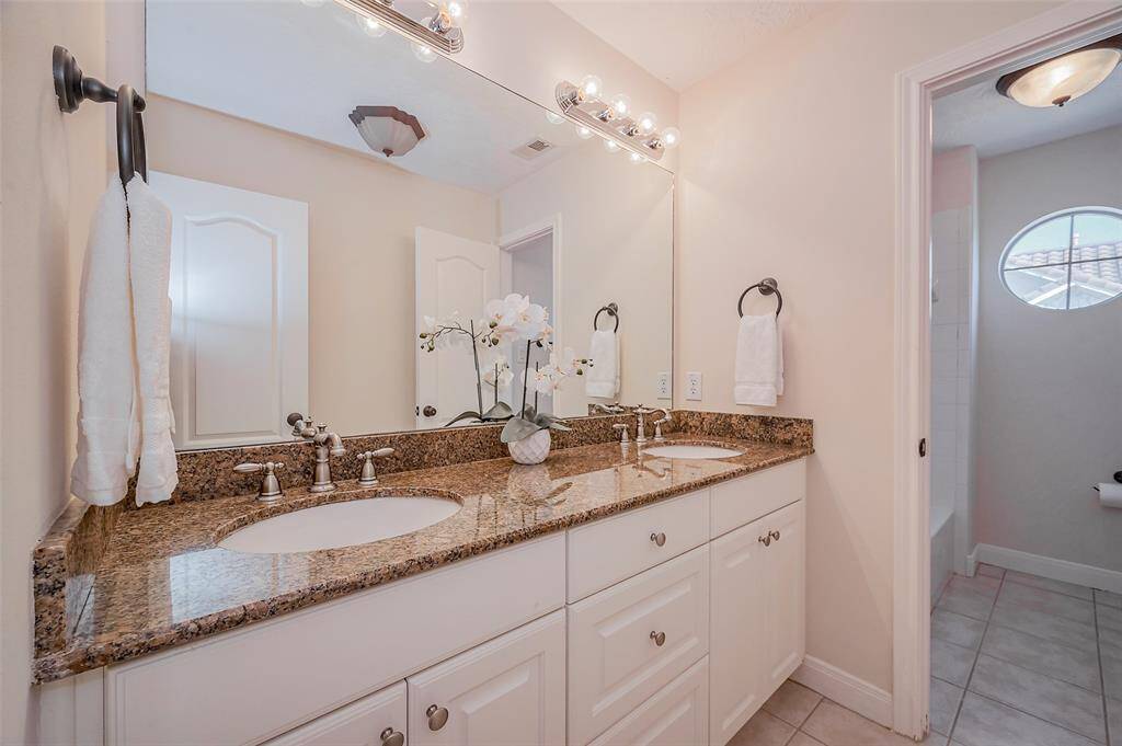Hall bathroom with double sinks shared by bedrooms 3 and 4 has a shower/tub combo.