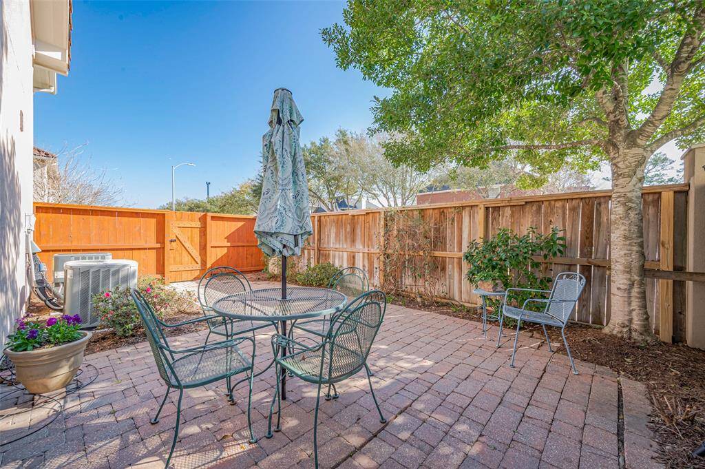 Nice view of patio with pavers and a great shade tree.