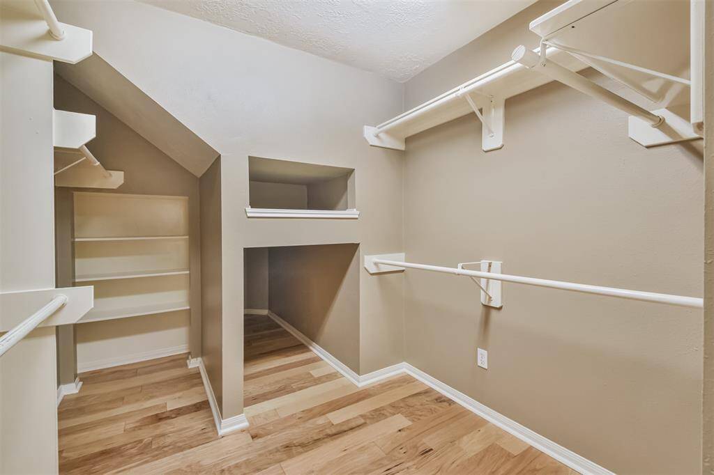 The primary closet has so much storage with extra shelving and storage space for suitcases or bulky items.