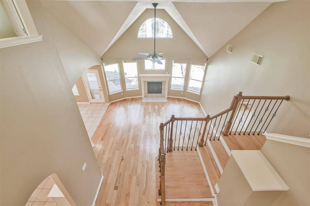 The living room and stairs from the upstairs walkway. The two story living room creates feelings of spaciousness and expansiveness.