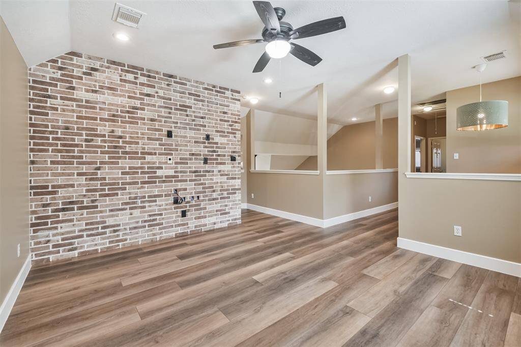 The gameroom wall features an accent brick wall.